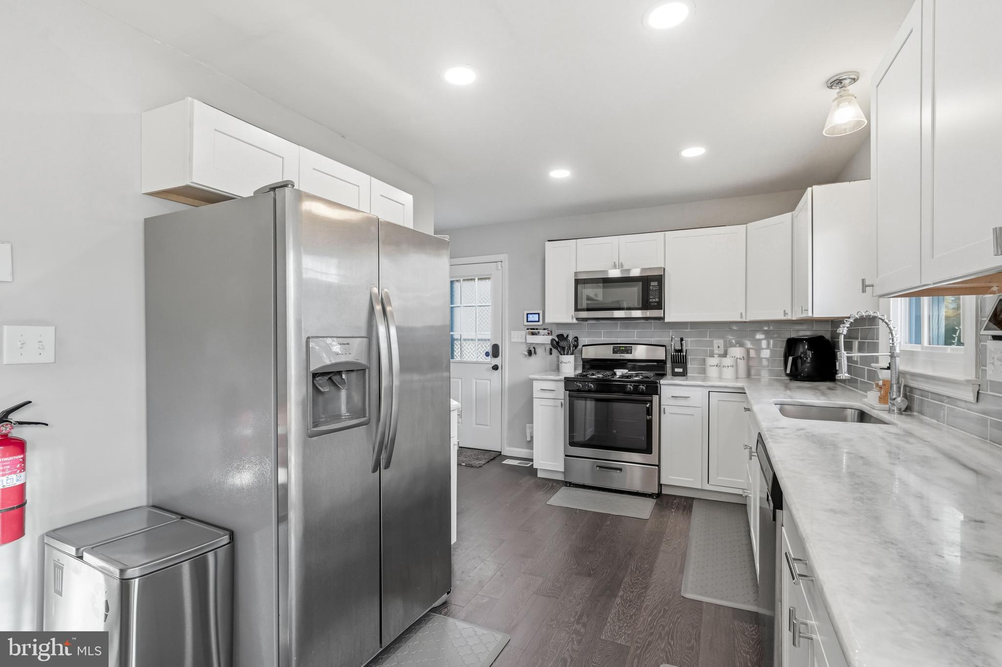 16 Sumner Avenue Berlin, NJ 08009 - Photo 11 of 30 a kitchen with granite countertop a refrigerator and a stove top oven