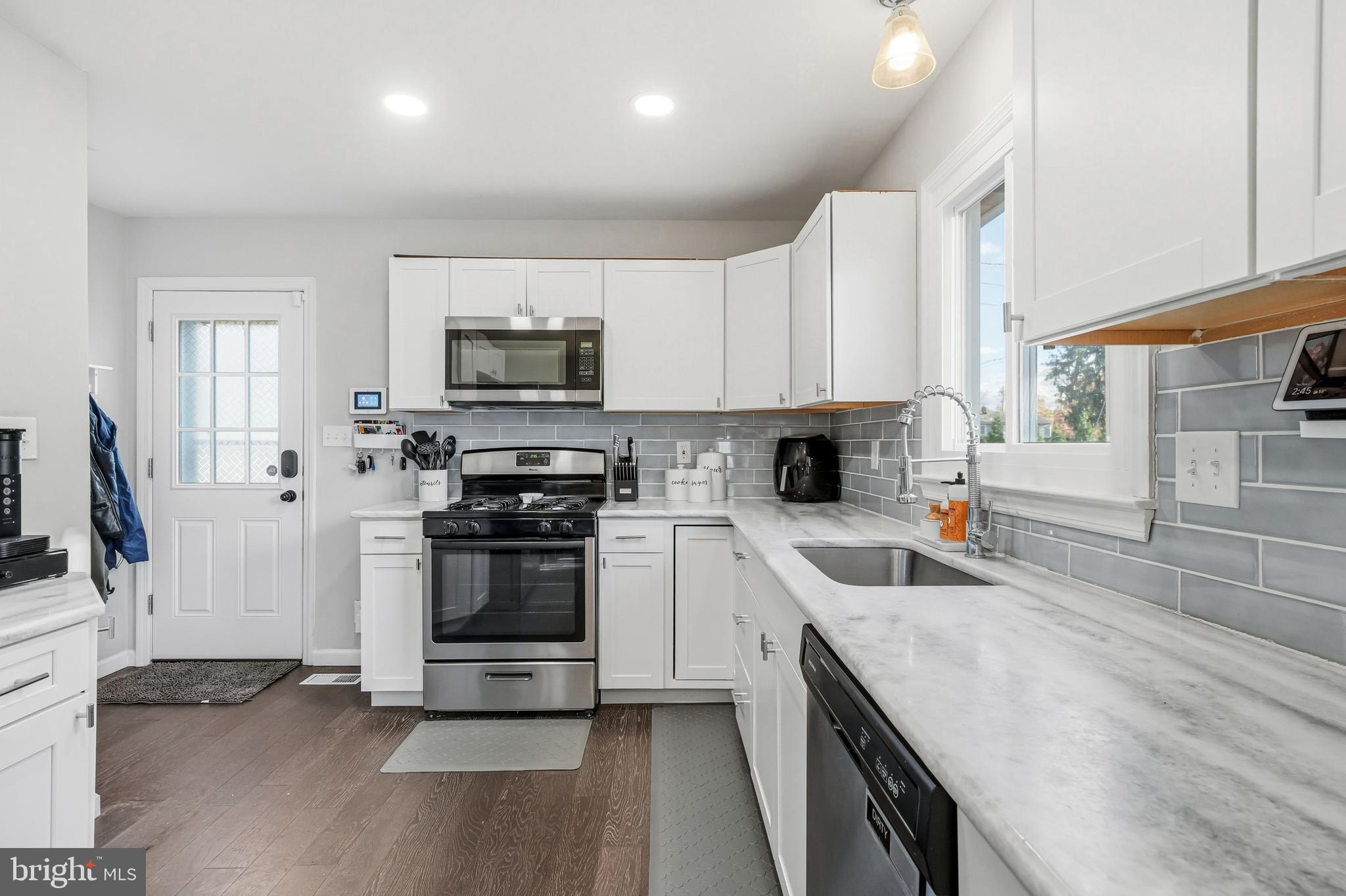 16 Sumner Avenue Berlin, NJ 08009 - Photo 10 of 30 a kitchen with granite countertop a stove top oven a sink dishwasher and a refrigerator with wooden floor