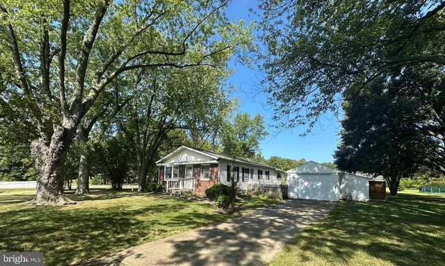 a view of a big house with a big yard and large trees