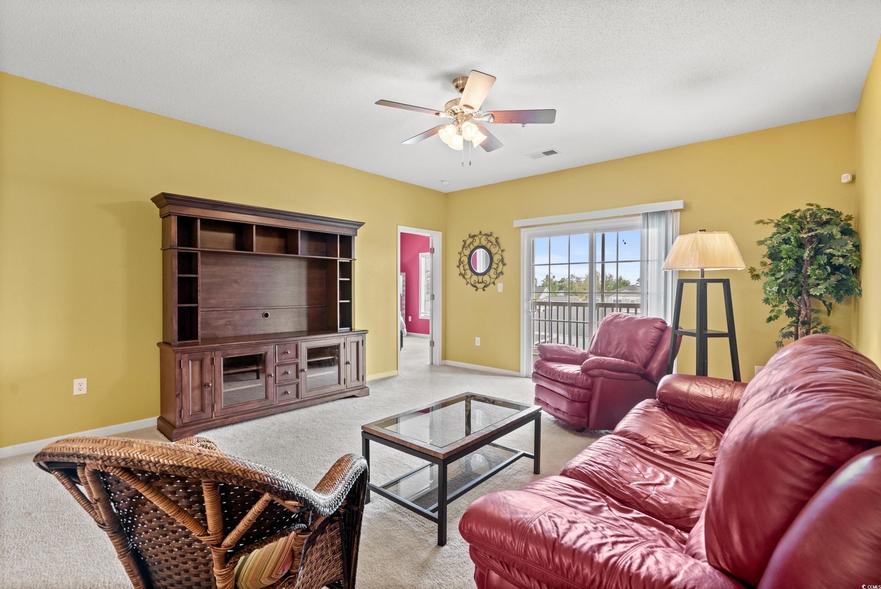 2050 Cross Gate Boulevard, Unit 303 Myrtle Beach, SC 29575 - Photo 11 of 35 Living room featuring a textured ceiling, ceiling fan, and carpet flooring