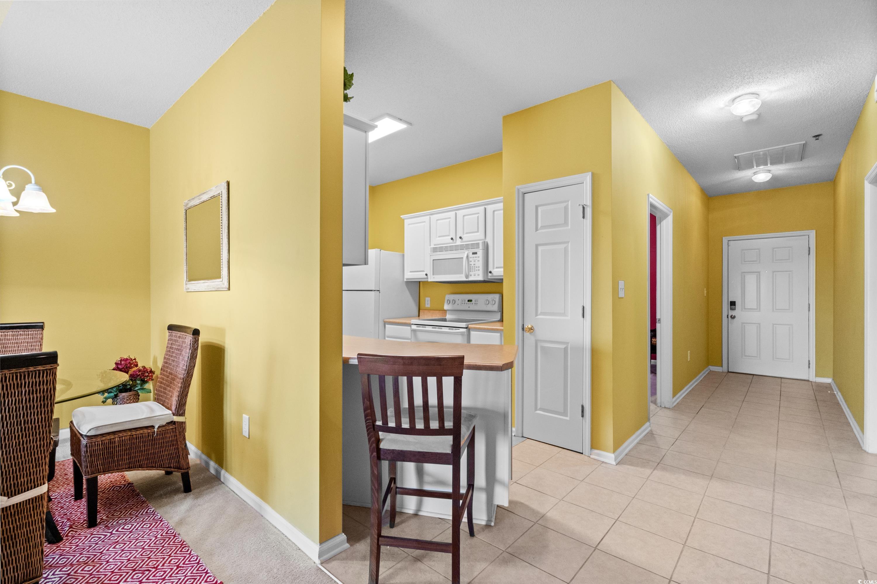 2050 Cross Gate Boulevard, Unit 303 Myrtle Beach, SC 29575 - Photo 12 of 35 Corridor with a textured ceiling and light tile patterned flooring