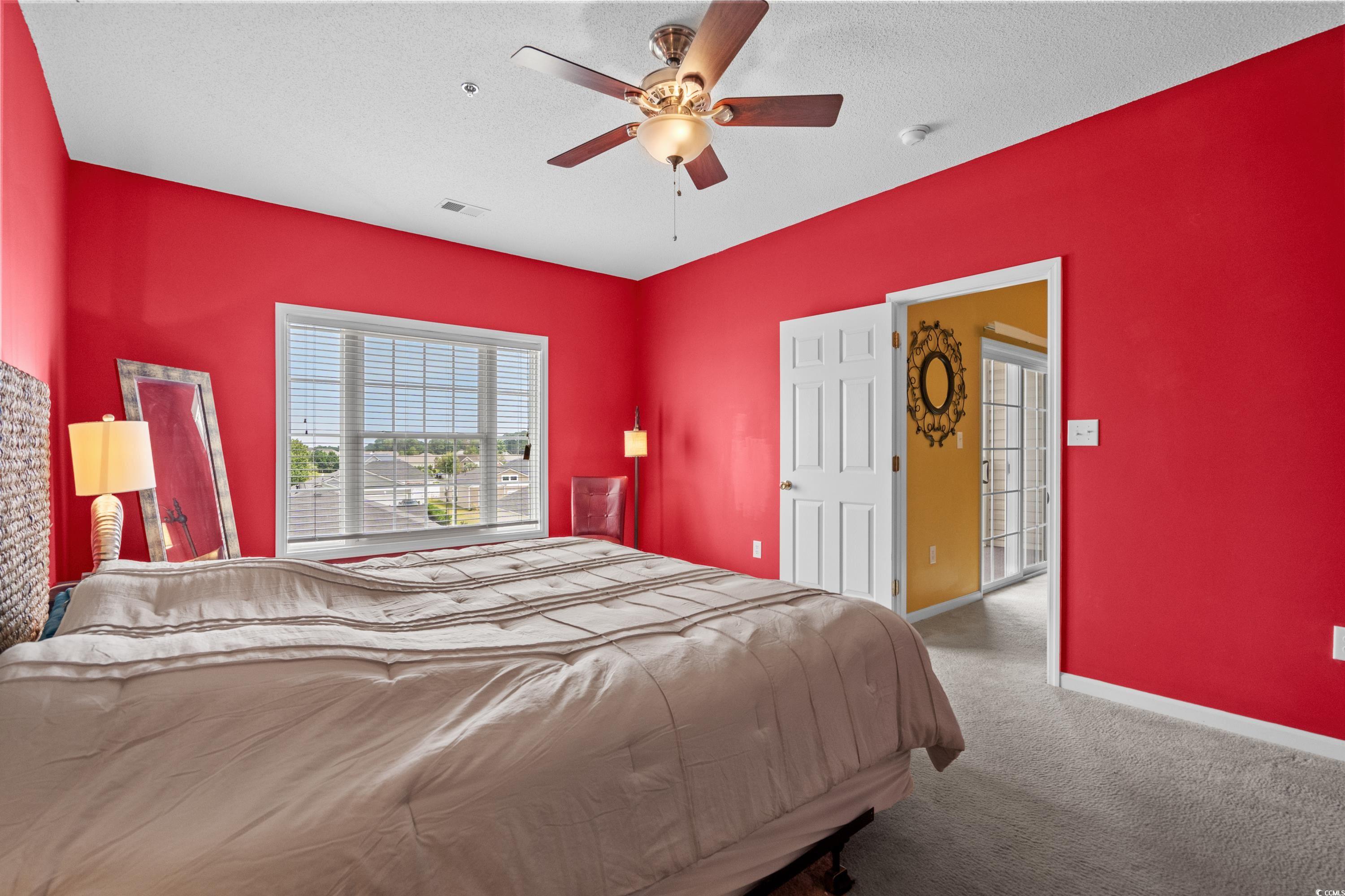 2050 Cross Gate Boulevard, Unit 303 Myrtle Beach, SC 29575 - Photo 21 of 35 Bedroom featuring a textured ceiling, carpet flooring, and ceiling fan