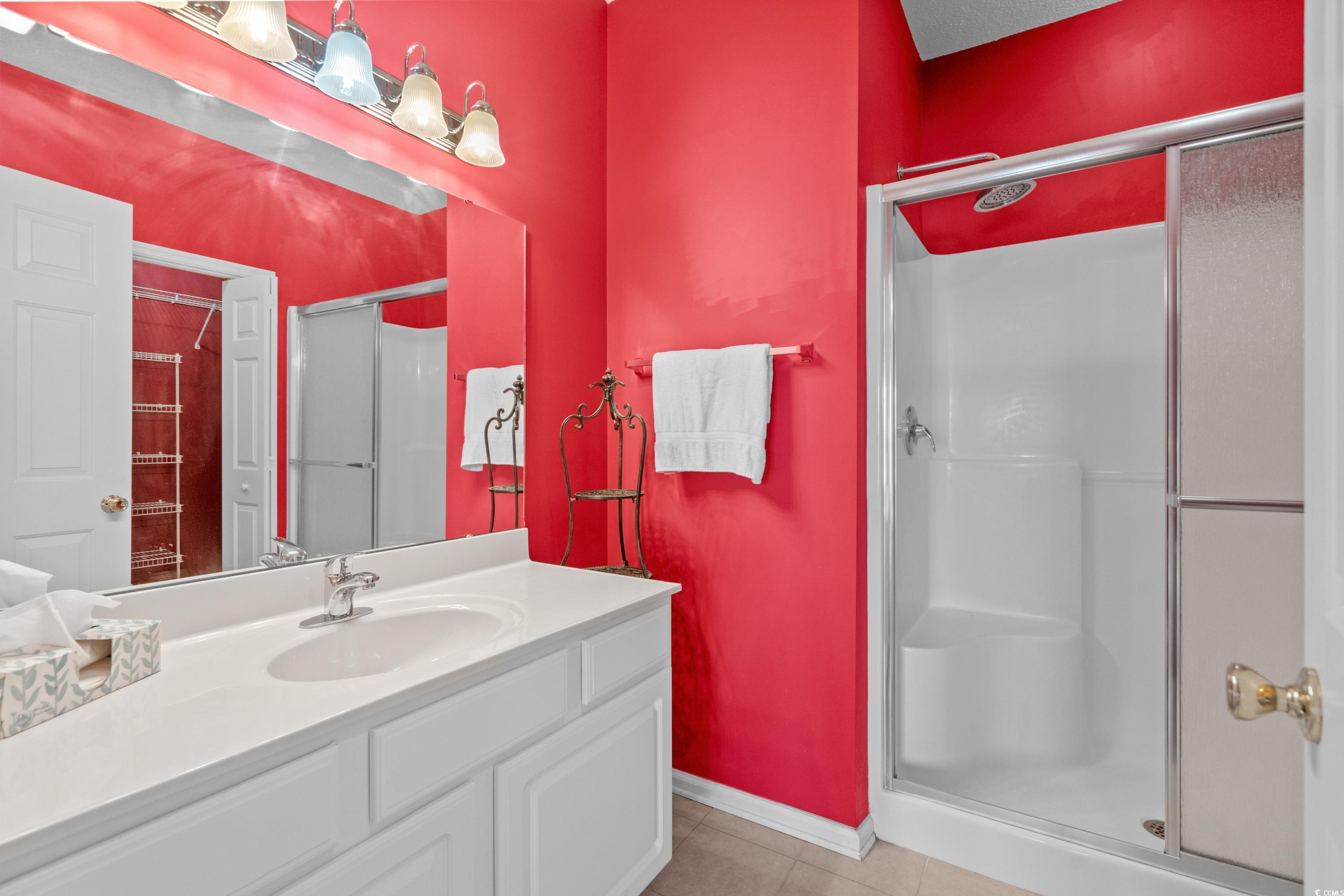 2050 Cross Gate Boulevard, Unit 303 Myrtle Beach, SC 29575 - Photo 22 of 35 Bathroom with tile patterned flooring, an enclosed shower, and vanity
