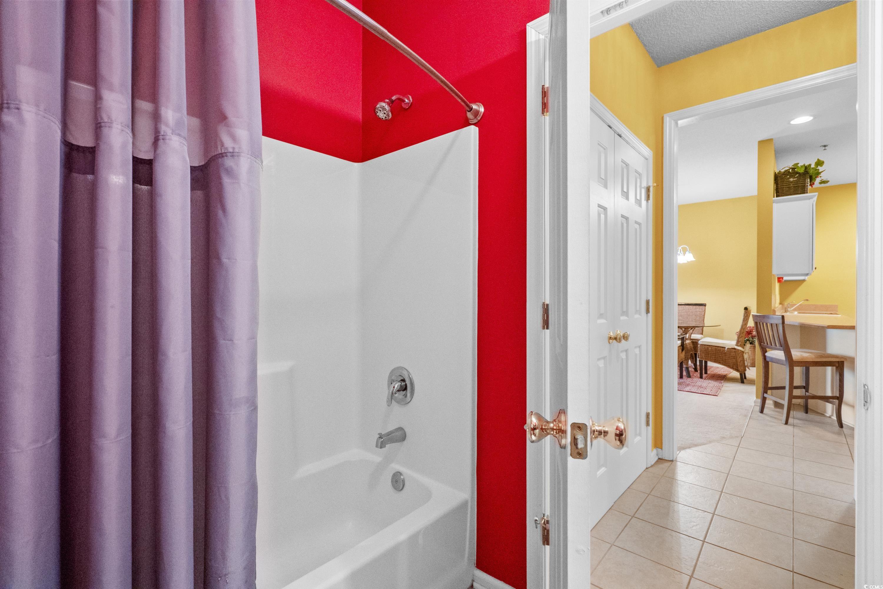 2050 Cross Gate Boulevard, Unit 303 Myrtle Beach, SC 29575 - Photo 29 of 35 Bathroom featuring tile patterned flooring, a textured ceiling, and shower / bathtub combination with curtain