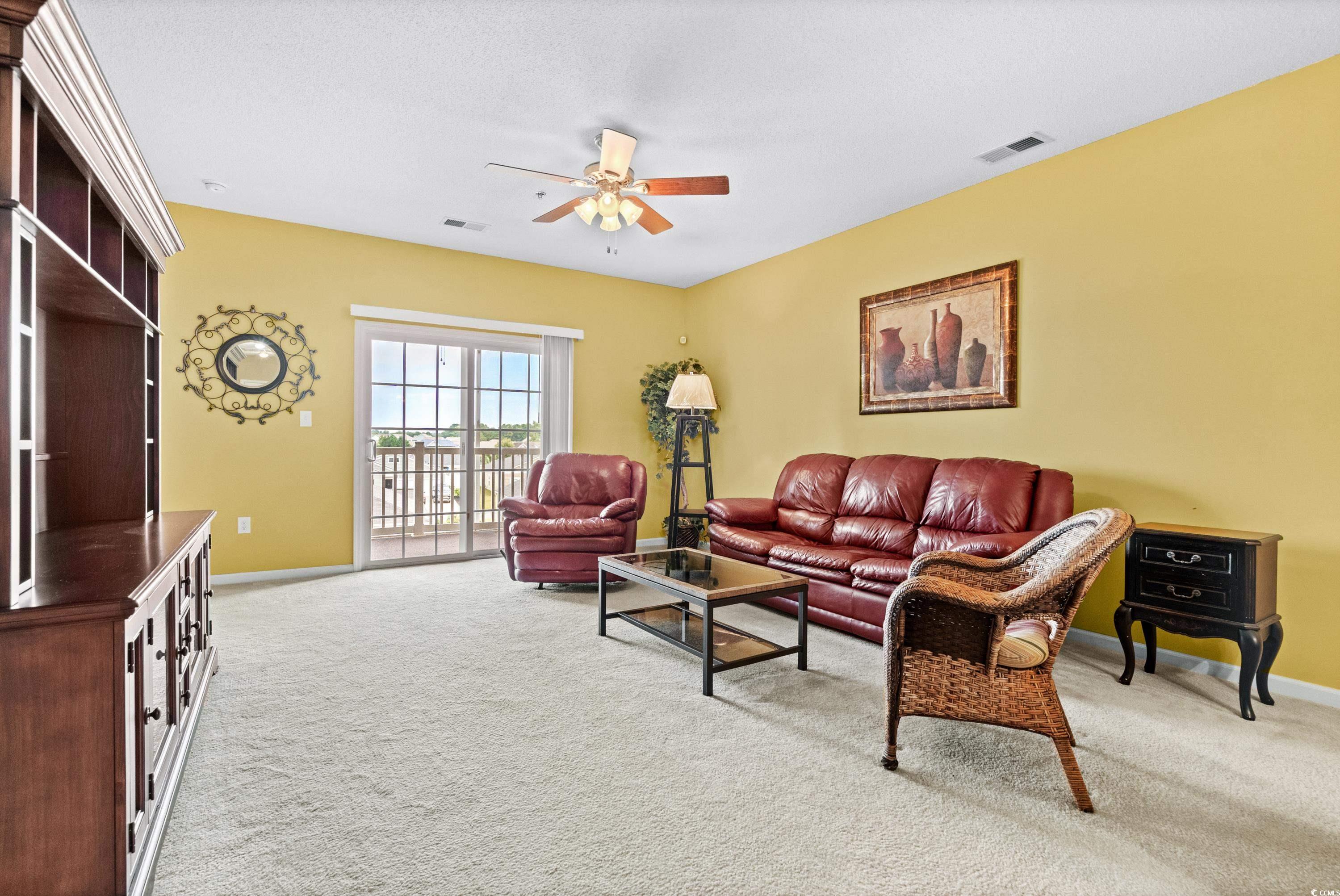 2050 Cross Gate Boulevard, Unit 303 Myrtle Beach, SC 29575 - Photo 6 of 35 Carpeted living room with ceiling fan