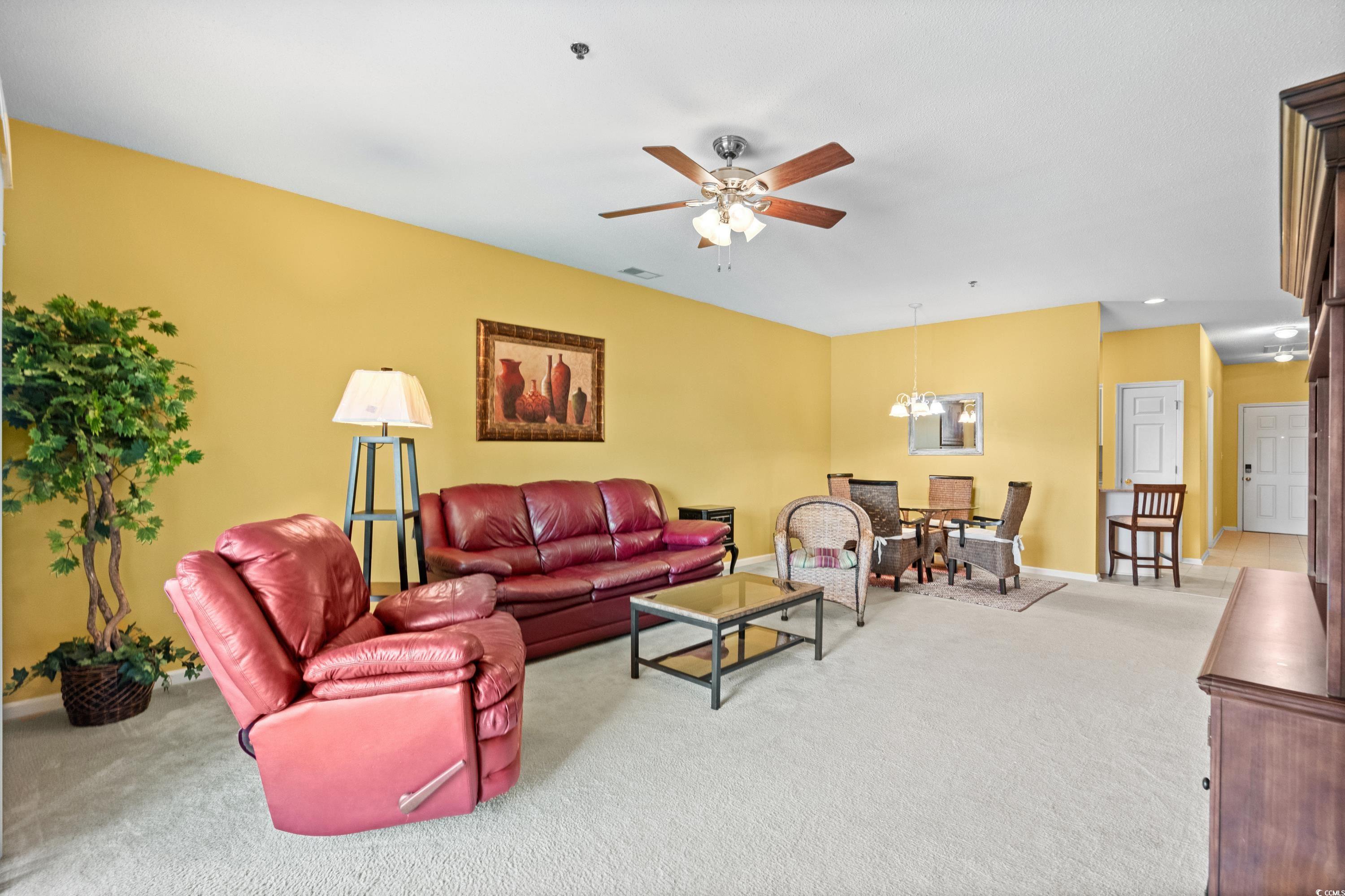 2050 Cross Gate Boulevard, Unit 303 Myrtle Beach, SC 29575 - Photo 7 of 35 Carpeted living room featuring ceiling fan with notable chandelier