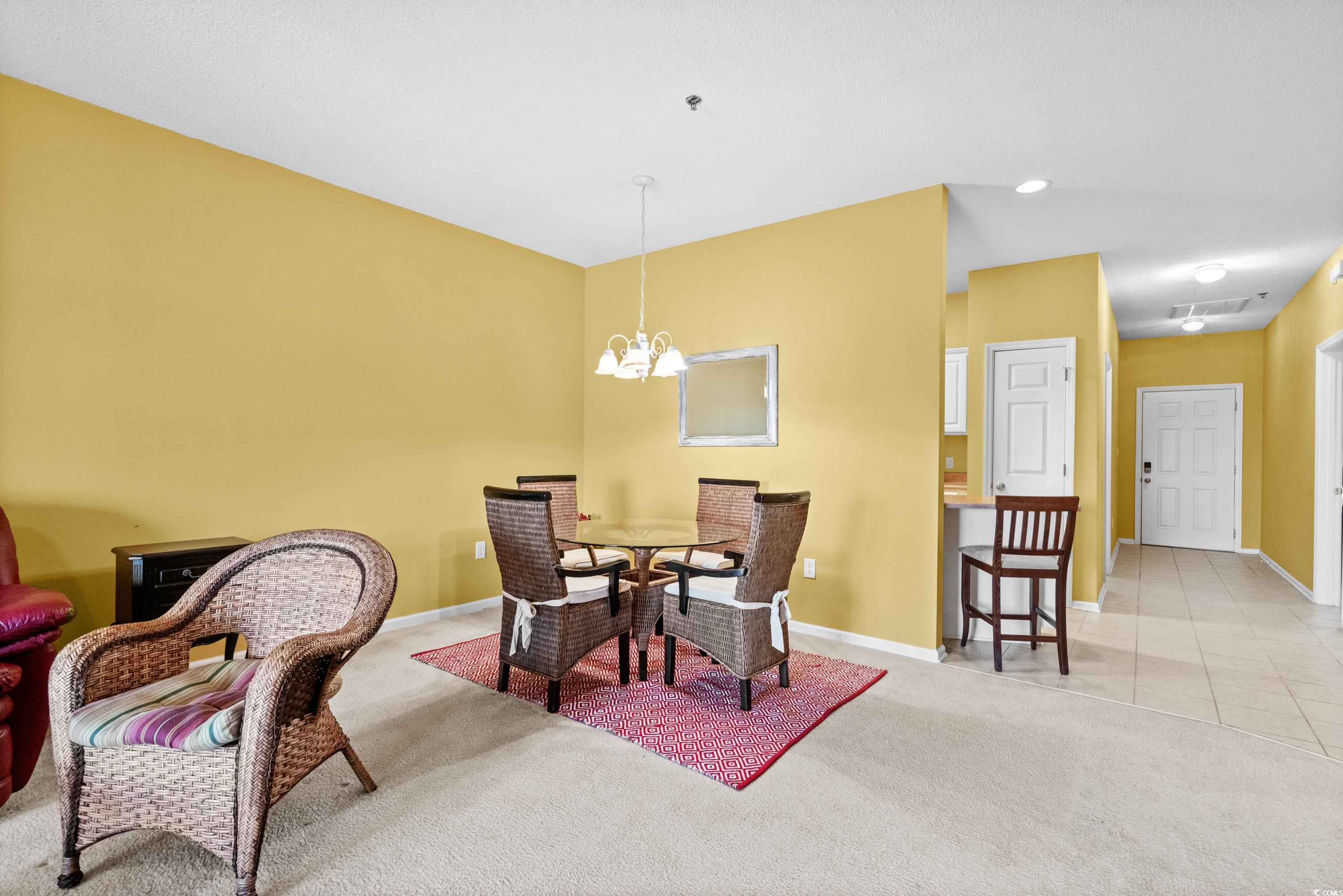 2050 Cross Gate Boulevard, Unit 303 Myrtle Beach, SC 29575 - Photo 9 of 35 Dining space featuring light colored carpet and a notable chandelier