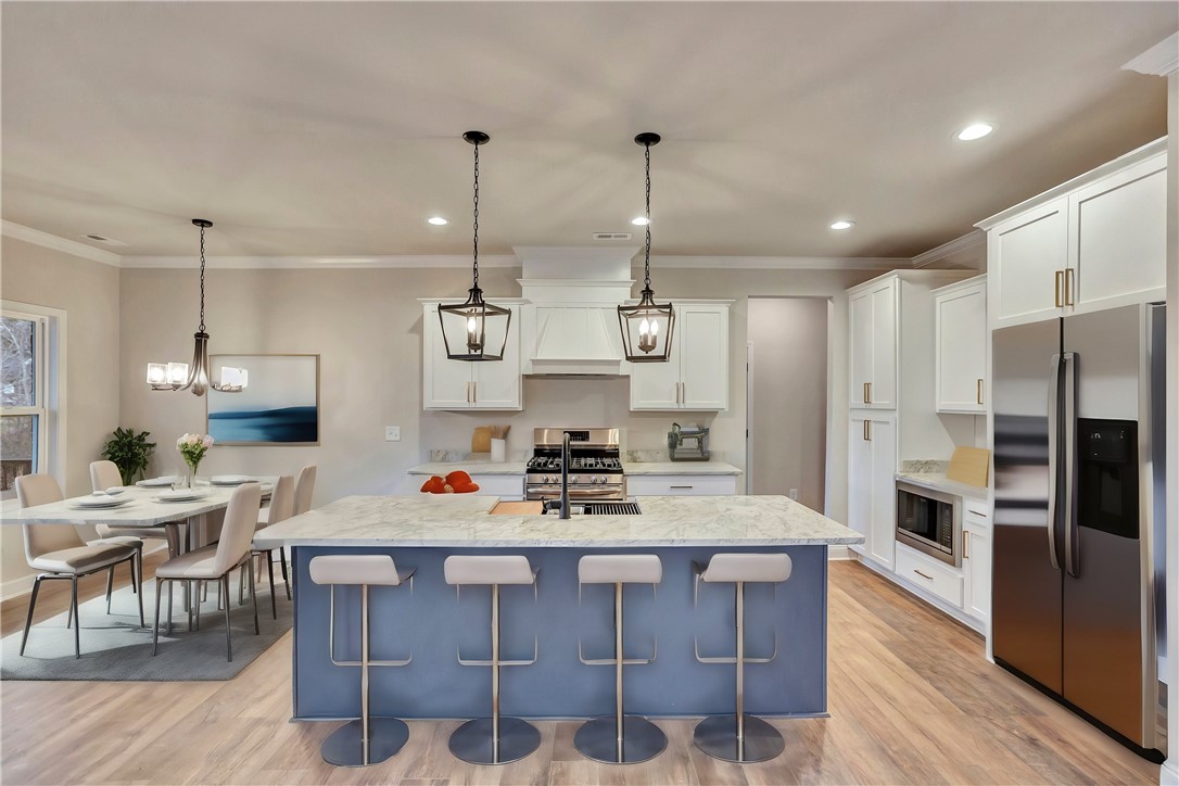 118 Bonaire Point Anderson, SC 29621 - Photo 7 of 23 This modern kitchen features a spacious island and seamlessly connects to a bright dining area.