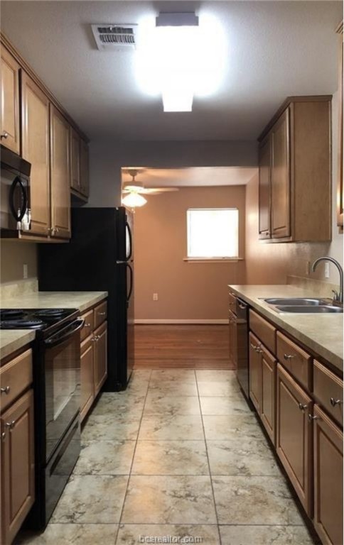 1601 South College Avenue Bryan, TX 77801 - Photo 4 of 11 Kitchen with black appliances and a ceiling fan
