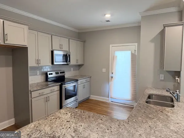 a kitchen with stainless steel appliances granite countertop a sink stove and refrigerator