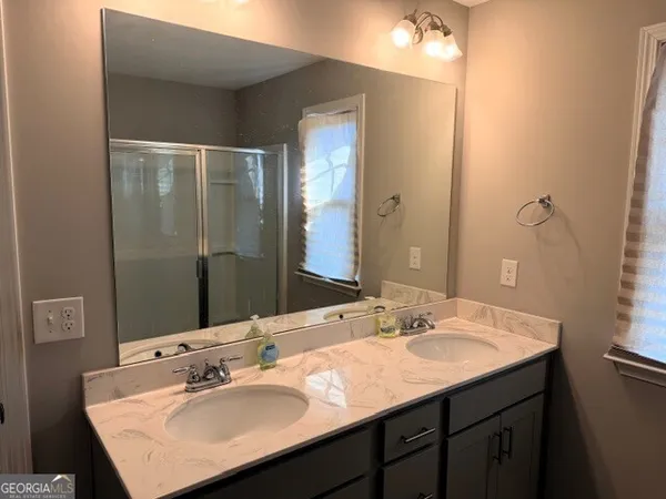 a bathroom with a sink vanity granite and a mirror