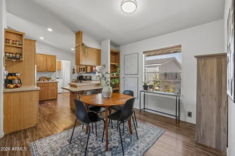 a kitchen with stainless steel appliances granite countertop a refrigerator a sink dishwasher a stove and white cabinets with wooden floor