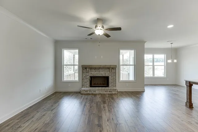 wooden floor fireplace and windows in an empty room