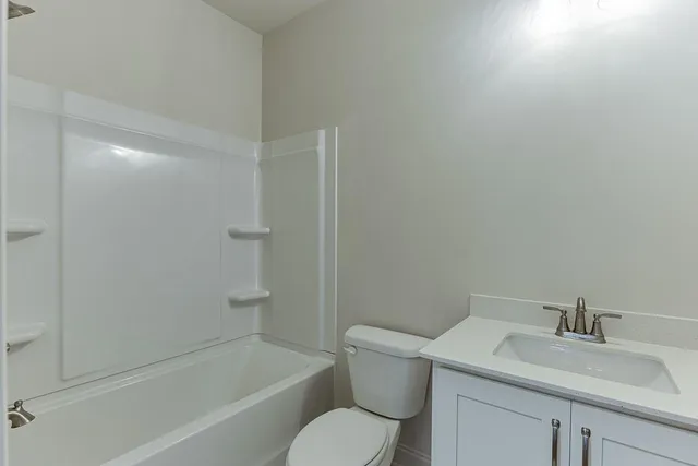 a white toilet sitting next to a bath tub