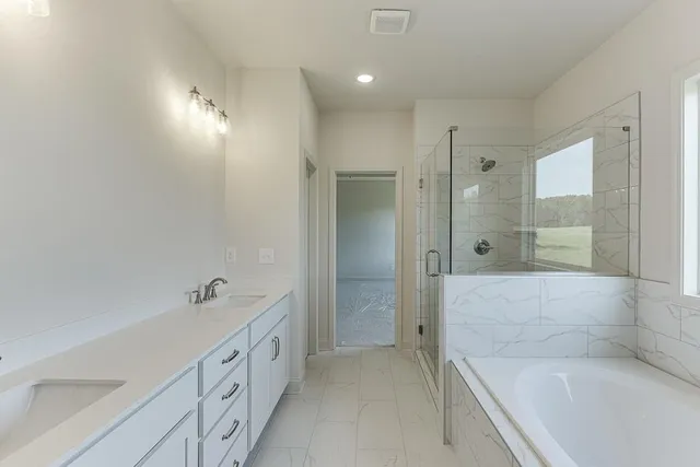 a spacious bathroom with a tub shower and sink