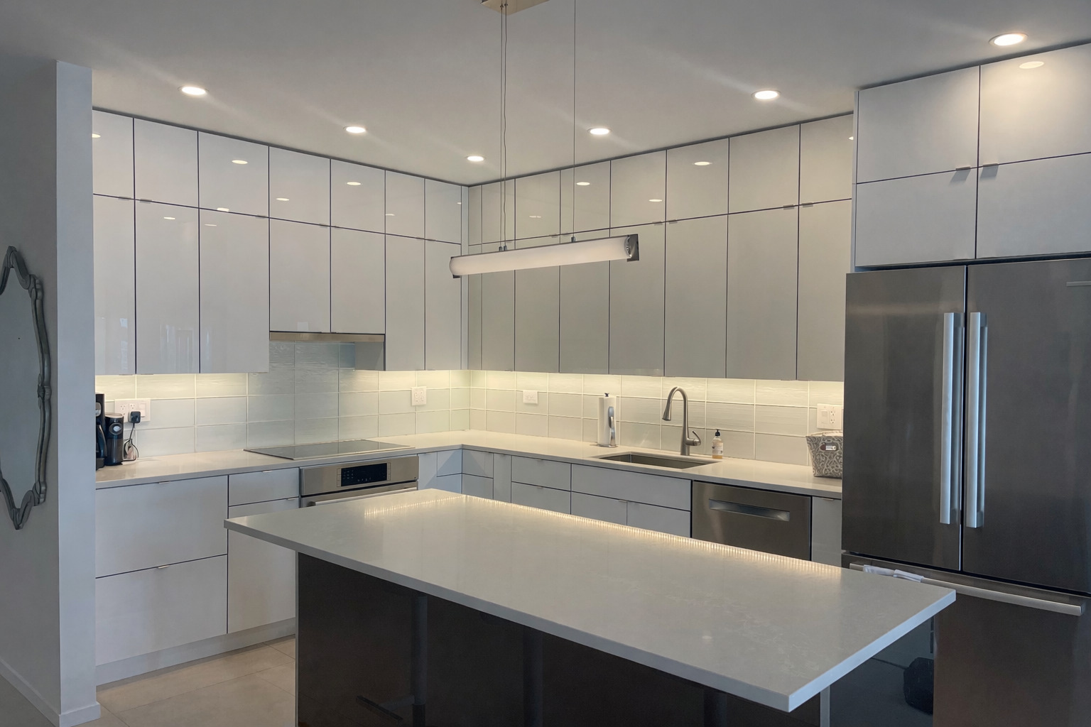175 East Delaware Place, Unit 4723 Chicago, IL 60611 - Photo 5 of 26 a kitchen with kitchen island white cabinets and stainless steel appliances