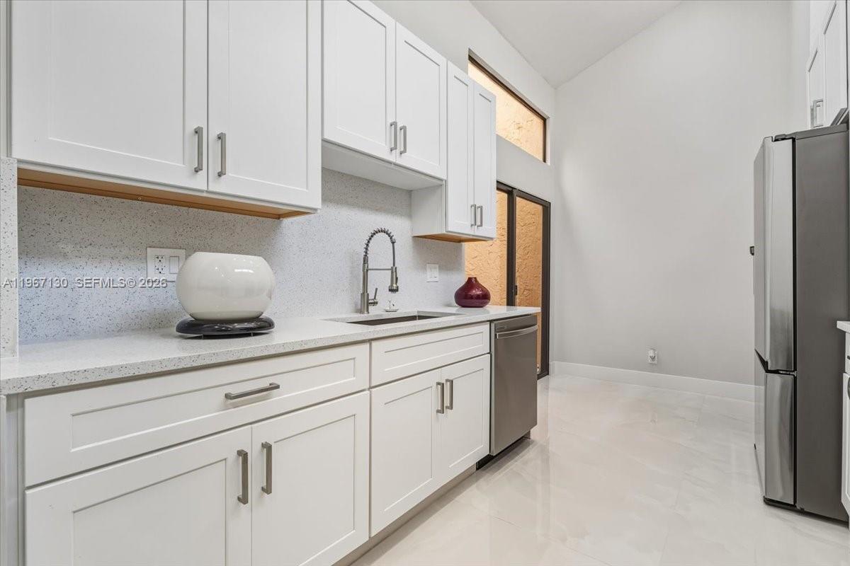 22708 Meridiana Drive Boca Raton, FL 33433 - Photo 13 of 49 a kitchen with stainless steel appliances a sink and cabinets