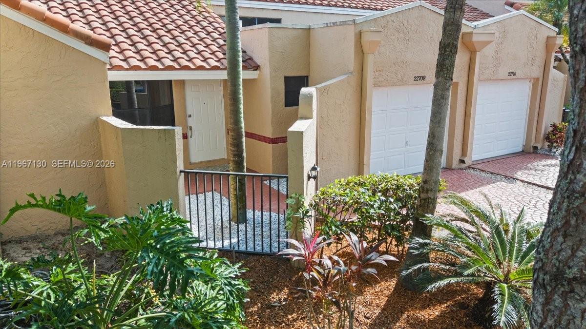 22708 Meridiana Drive Boca Raton, FL 33433 - Photo 34 of 49 an entrance to house with yard and seating area