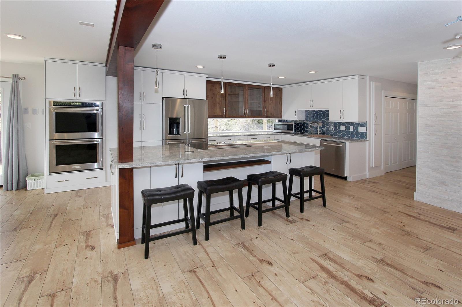 6250 Waterfall Loop Manitou Springs, CO 80829 - Photo 2 of 36 a kitchen with kitchen island granite countertop a table chairs microwave and cabinets