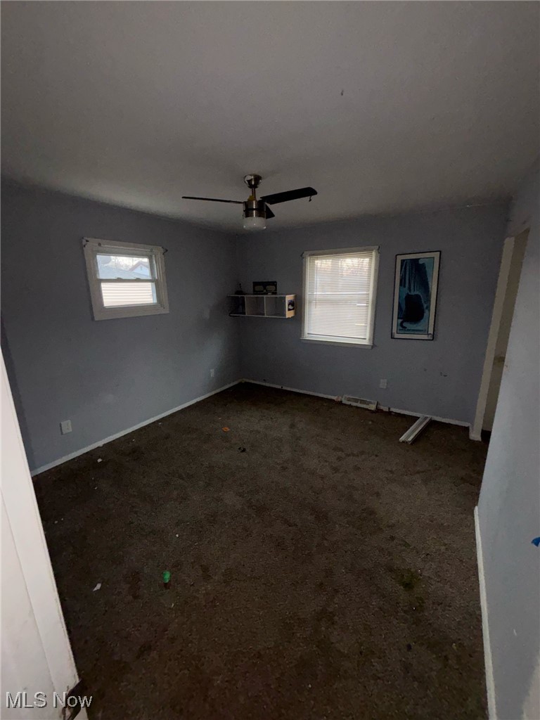 5930 Lake Road Mentor, OH 44060 - Photo 3 of 11 Empty room featuring healthy amount of natural light, dark carpet, and ceiling fan