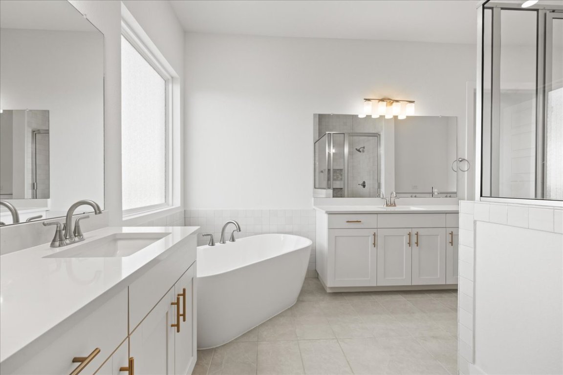 220 Begonia Street Buda, TX 78610 - Photo 13 of 24 a bathroom with a double vanity sink mirror and bathtub
