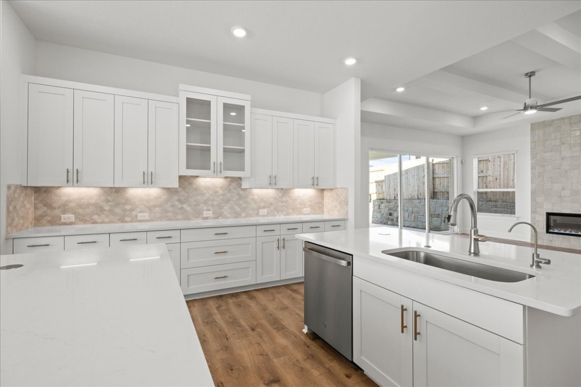 220 Begonia Street Buda, TX 78610 - Photo 8 of 24 a kitchen with granite countertop a sink and white cabinets