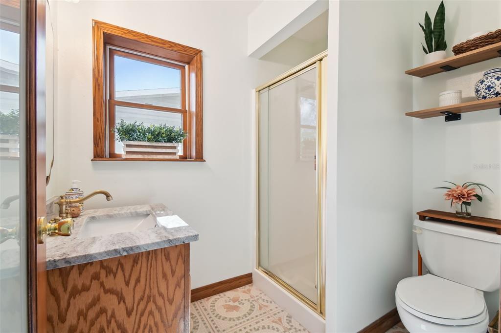 6128 Oak Ridge Avenue New Port Richey, FL 34653 - Photo 13 of 55 a bathroom with a granite countertop sink toilet and mirror