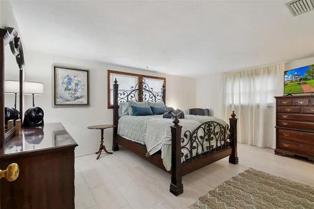 a bedroom with a bed a mirror and dresser