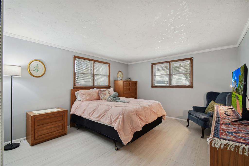 6128 Oak Ridge Avenue New Port Richey, FL 34653 - Photo 32 of 55 a bedroom with a bed table chair and a window