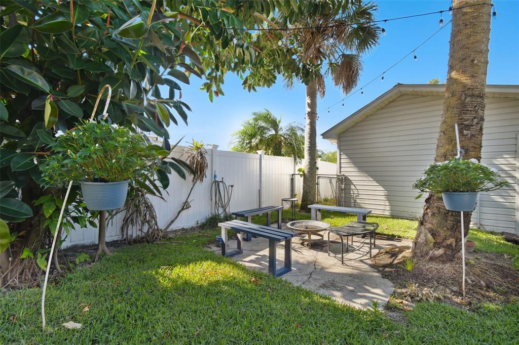 6128 Oak Ridge Avenue New Port Richey, FL 34653 - Photo 40 of 55 a view of a backyard with chairs potted plants and a large tree