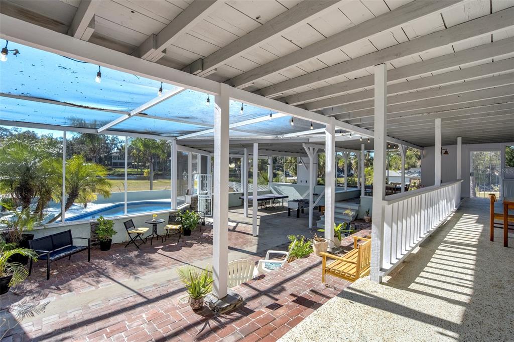 6128 Oak Ridge Avenue New Port Richey, FL 34653 - Photo 4 of 55 a view of a patio with table and chairs potted plants with floor to ceiling window