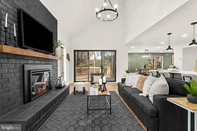 a living room with furniture kitchen view and a wooden floor