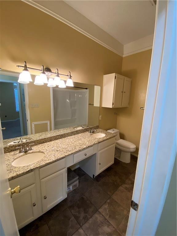 2802 Nueces Street, Unit 311 Austin, TX 78705 - Photo 10 of 13 a bathroom with a granite countertop sink mirror vanity and toilet