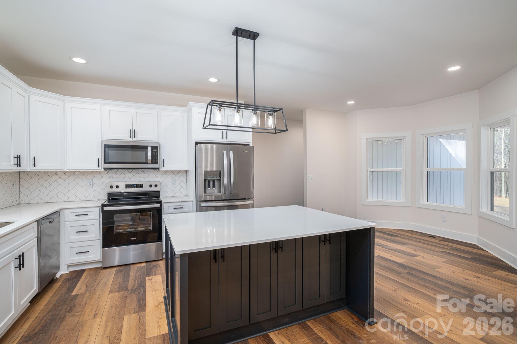 6335 Forney Hill Road Denver, NC 28037 - Photo 11 of 46 a kitchen with kitchen island white cabinets appliances and sink