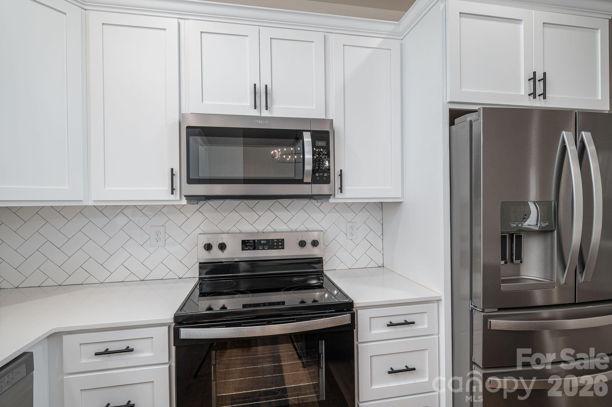 6335 Forney Hill Road Denver, NC 28037 - Photo 13 of 46 a kitchen with stainless steel appliances granite countertop white cabinets and a stove a refrigerator with wooden floors