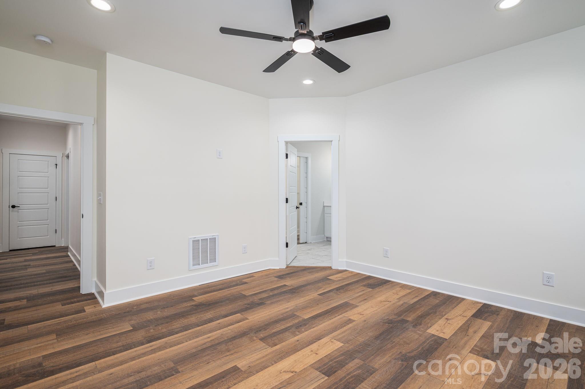6335 Forney Hill Road Denver, NC 28037 - Photo 16 of 46 an empty room with wooden floor ceiling fan and windows