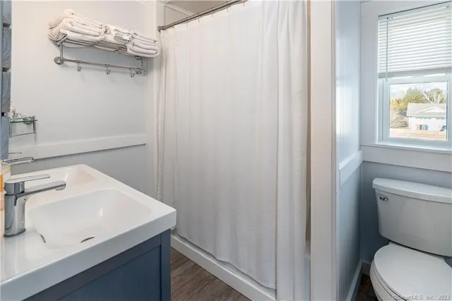 a bathroom with a sink a toilet and window