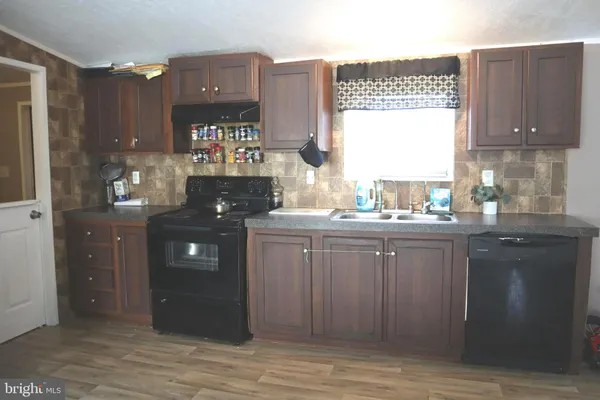 a kitchen with a sink cabinets and wooden floor