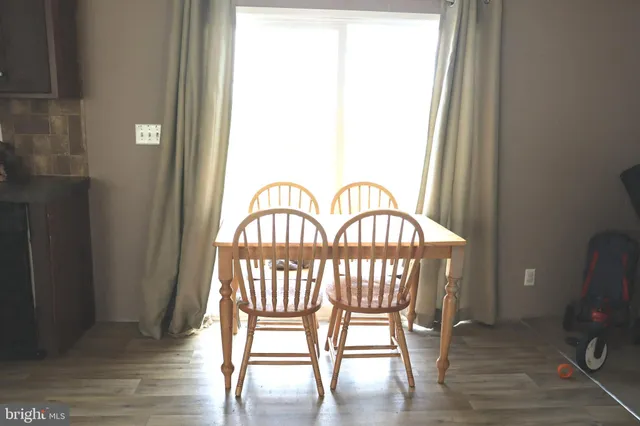 a view of a a dining room with furniture window and wooden floor