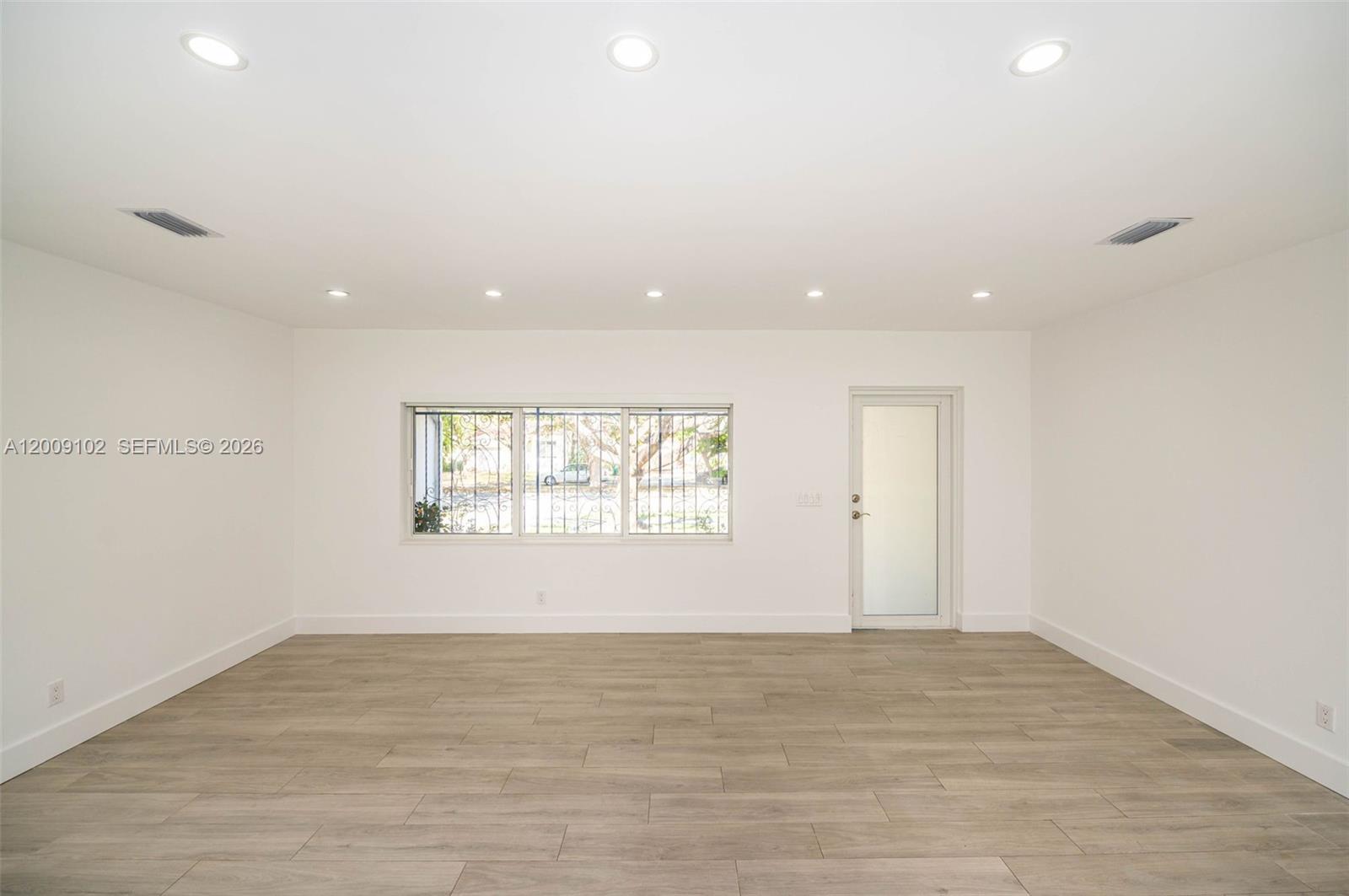 330 Southwest 27th Road Miami, FL 33129 - Photo 4 of 62 an empty room with wooden floor and windows