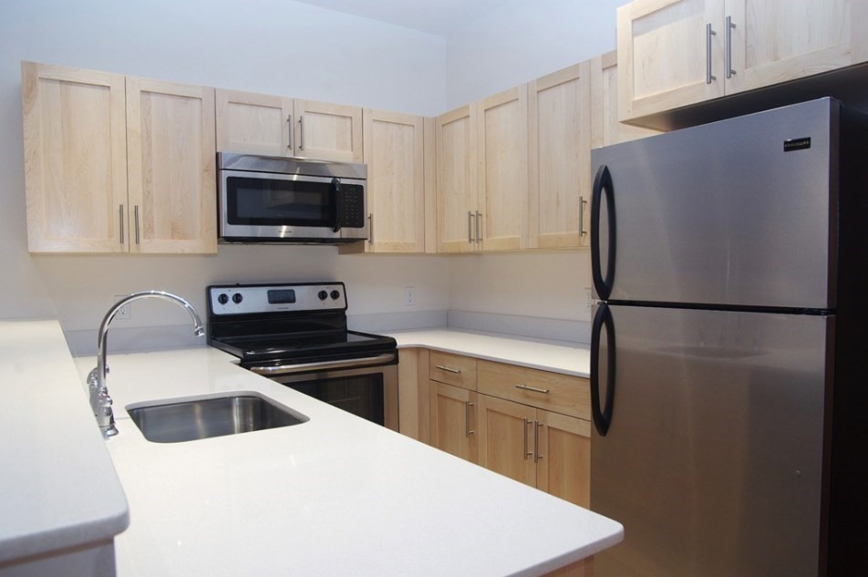 a kitchen with stainless steel appliances a refrigerator stove top oven and sink
