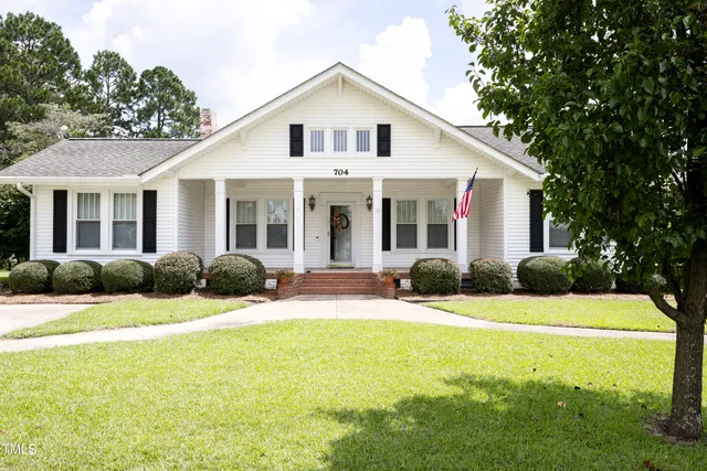 a front view of a house with yard and green space
