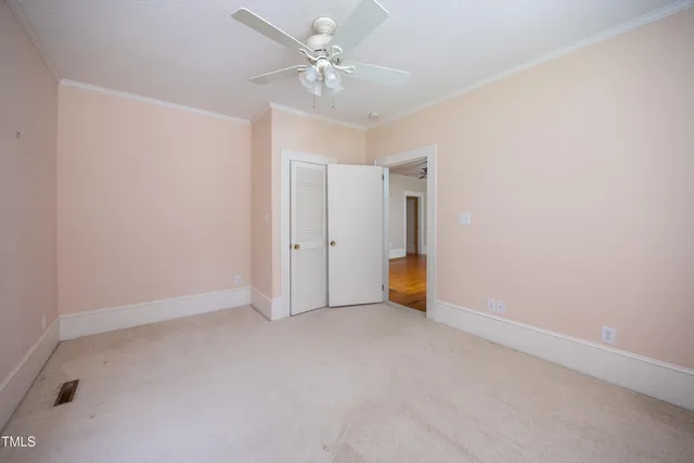 an empty room with a ceiling fan and a window