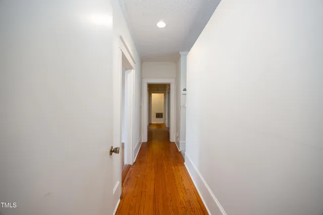 a view of a hallway with wooden floor