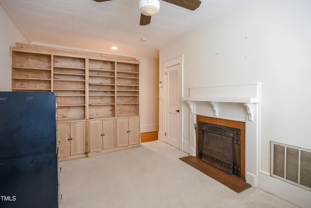 an empty room with a fireplace and cabinets