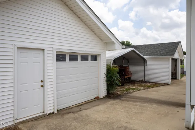 a view of a house with a small yard and garage