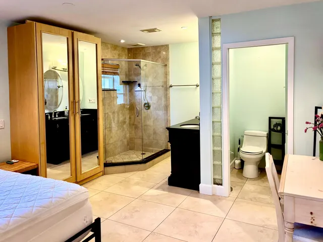a bathroom with a granite countertop sink a toilet and shower