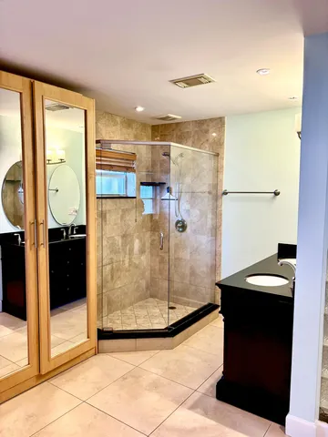 a bathroom with a glass shower door and a sink