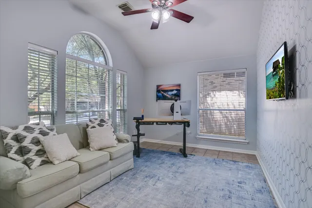 a small yard with large trees and wooden fence