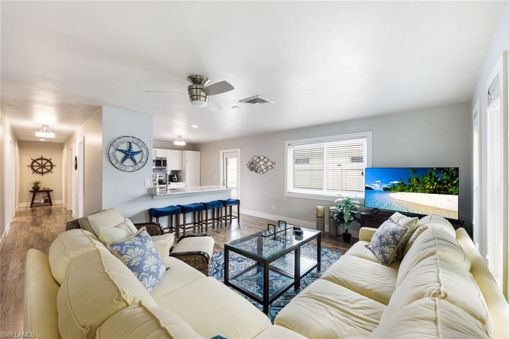 645 101st Avenue North Naples, FL 34108 - Photo 1 of 24 a living room with furniture a clock and a window